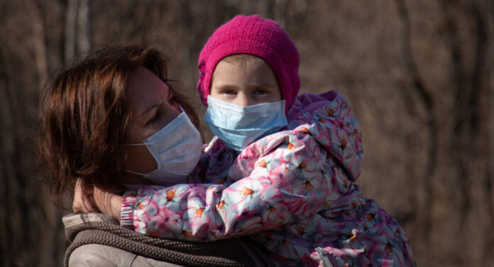 child and mom in facemasks