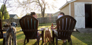 A couple and their dogs enjoying the back yard. Photo by KaLisa Veer on Unsplash.