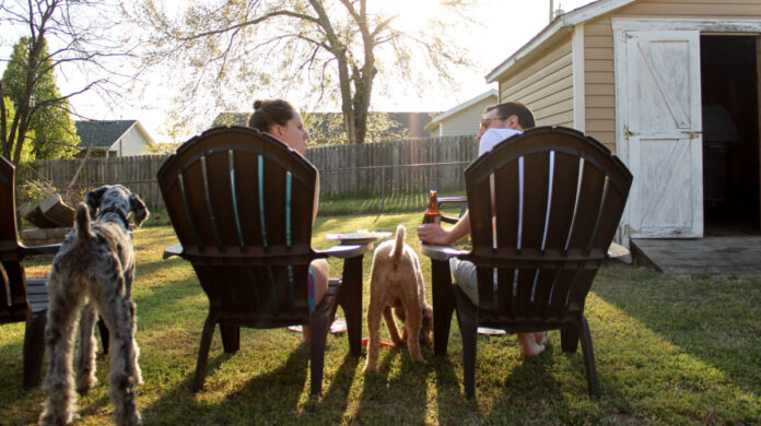 A couple and their dogs enjoying the back yard. Photo by KaLisa Veer on Unsplash.