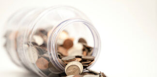 Coins spill from a jar. Photo by Michael Longmire on Unsplash