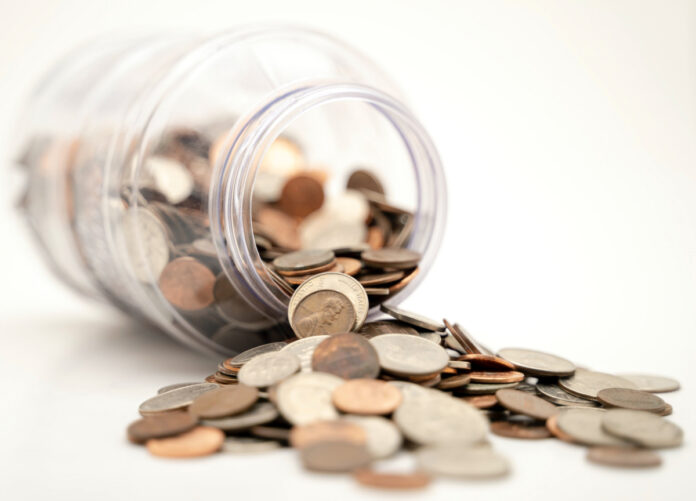 Coins spill from a jar. Photo by Michael Longmire on Unsplash