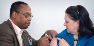 A doctor gives an immunization to a patient. Photo by CDC on Unsplash.