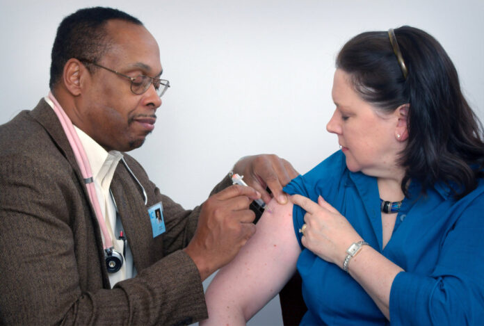 A doctor gives an immunization to a patient. Photo by CDC on Unsplash.