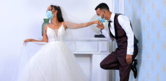 A bride and groom wearing surgical masks. Photo by mulugeta wolde on Unsplash.