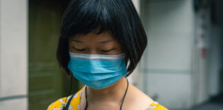 A woman wearing a face mask to reduce transmission of COVID-19. Photo by Li Lin on Unsplash.