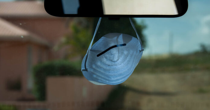 mask hanging from a rear view mirror. Photo by Matt Wilson on Unsplash