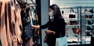 A woman shopping at a boutique hile wearing a face mask. Photo by Arturo Rey on Unsplash