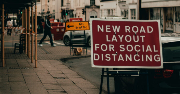Road sign on Social Distancing. Photo by Alex Motoc on Unsplash