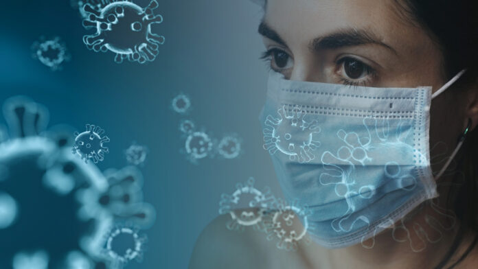 Illustration of coronavirus and a woman in a mask. Image by Tumisu from Pixabay