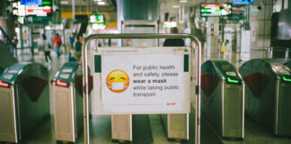 Sign asking mass transit riders to wear a face mask. Photo by Shawn Ang on Unsplash.