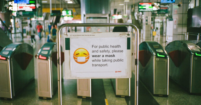 Sign asking mass transit riders to wear a face mask. Photo by Shawn Ang on Unsplash.