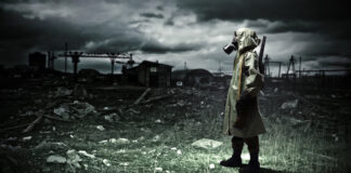 Man with gas mask and gun in a wasteland