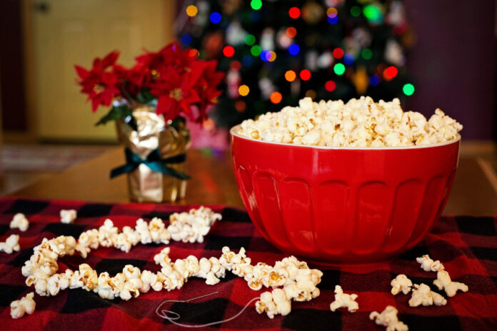 Popcorn in a bowl with a Christmas tree in the background. Photo by Jill Wellington from Pixabay.