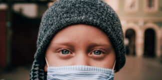 blue-eyed child in face mask and warm hat. Image by René Bittner from Pixabay.