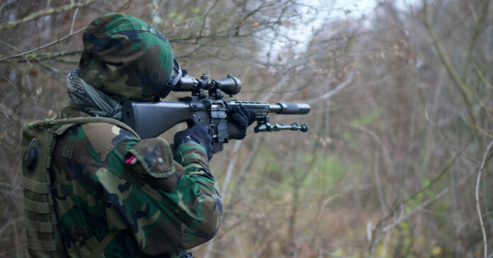 A rifle with a suppressor. Photo by Kony on Unsplash.