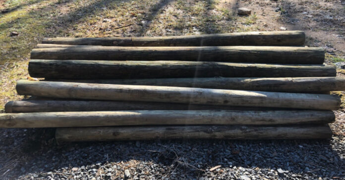 A pile of wooden fence posts.