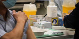 A man readies to receive a COVID-19 vaccination.