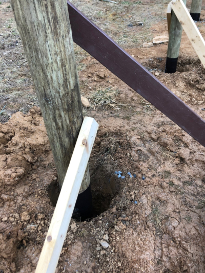 two scraps pieces of 2x4 lumber were used brace each post, ensuring it stayed straight up and plumb as we poured concrete around it.