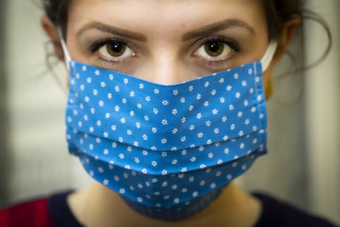 Female wearing a blue cloth mask. Image by Christo Anestev from Pixabay