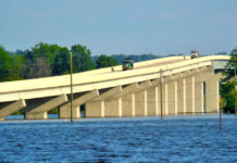 Dump trucks cross a bridge over the Mississippi River. Image by Mistyck Moon from Pixabay.