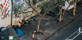 Homeless camp along a city street. Photo by Nathan Dumlao on Unsplash.