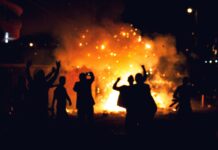 Rioters enjoy the flames of arson. Photo by Alex McCarthy on Unsplash.