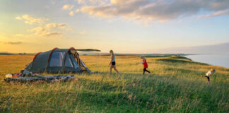 A family camping in a tent. Photo by Mattias Helge on Unsplash.