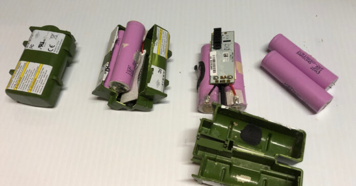 A modem pack in various stages of disassembly to recover the 18650 batteries inside.