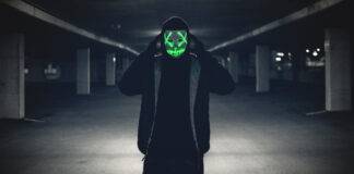 Man in a purge mask. Photo by Erik Mclean on Unsplash.
