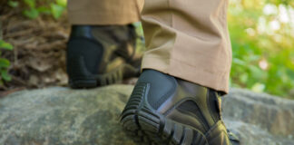 Black tactical boots worn in the woods.