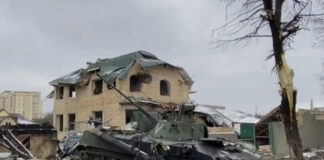 bombed out buildings and a destroyed armor vehicle from the Russian invasion of Ukraine.