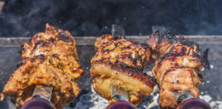 Chicken on skewers being cooked over coals