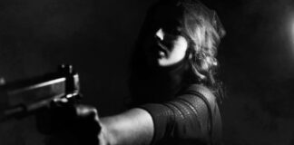A young woman prepared to defend herself with a pistol.