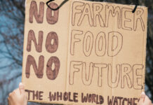 A protester holds a sign that says "no farmer - no food - no future."
