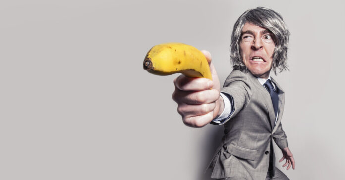 Man using a banana as a gun