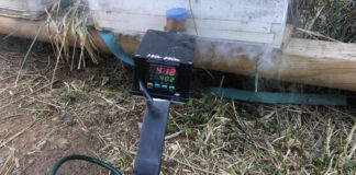 Pumping oxalic acid into a beehive to kill varroa mites.