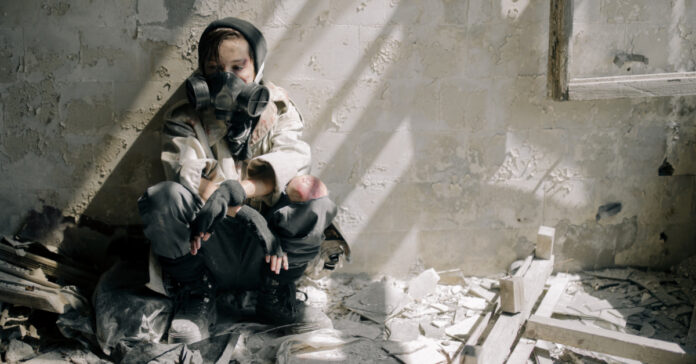 Woman in a gas mask in a destroyed building.