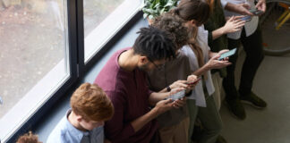 A line of people starting at their phones instead of talking to each other.