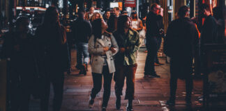 People on a crowded city sidewalk at night