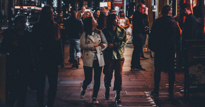 People on a crowded city sidewalk at night