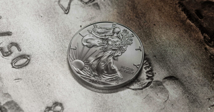 The U.S. Silver Eagle, a one-ounce silver coin, seen on a large bar of silver.