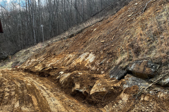 This muddy hillside isn't pretty looking, but it is a big improvement over what was there immediately following the landslide, when the mud was four feet thick. You can see where a section of the hill just slide away, leaving a muddy scar. The row of rocks at the bottom were too big for us to remove, so we pushed them up against the hillside.