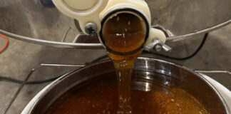 Honey pours out of the extractor, which uses centrifugal force to propel the honey out of the comb after we remove the wax capping.